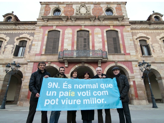 Un grup de voluntaris amb la pancarta davant del Parlament