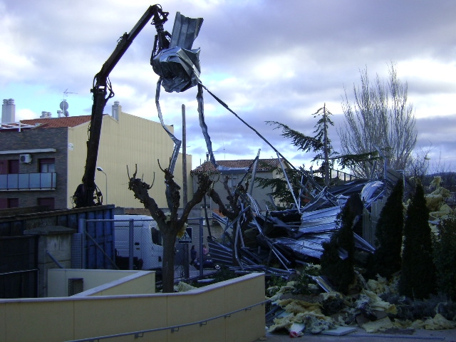 Una grua retirant les restes de la teulada de l'IES Montbui, el gener del 2009