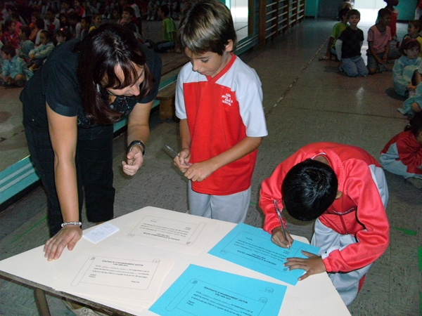Dos alumnes signant el contracte en un moment de l’acte