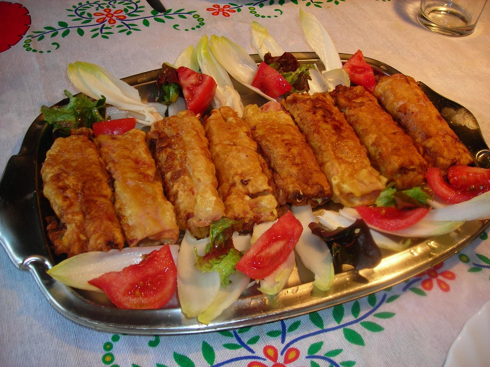 Rollets de porro i formatge embolicats amb pernil dolç