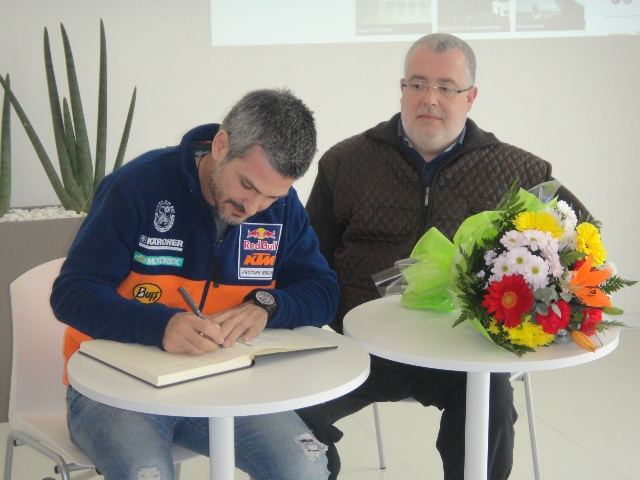 Viladoms ha signat el llibre de visites del Campus i Xavier Boquete ha lliurat al pilot un ram de flors i una cistella de productes anoiencs
