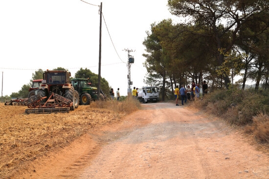 Un grup de pagesos seguint l'evolució del foc prop dels seus tractors a Sant Martí de Tous (Foto: Anna Ferràs/ACN)